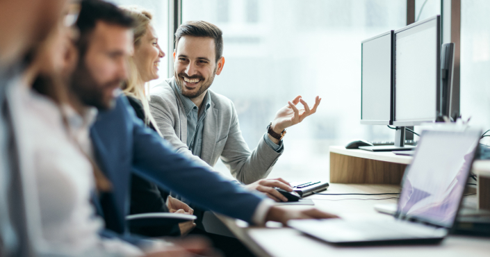 Man talking with co worker at computer