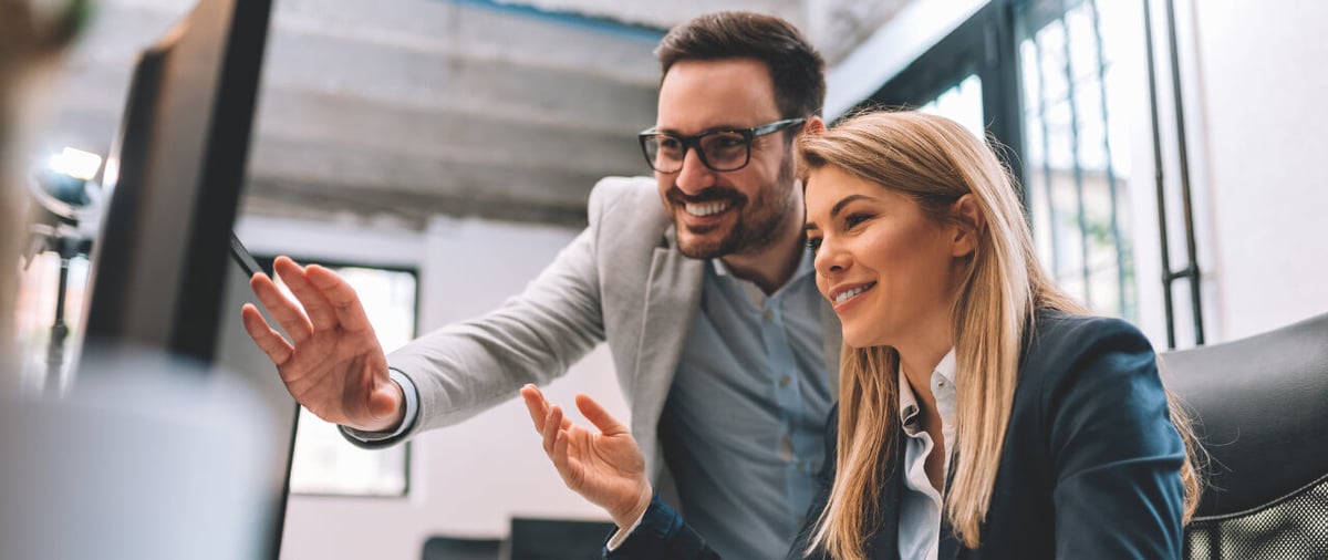 Header-Man and woman looking at screen comparing data