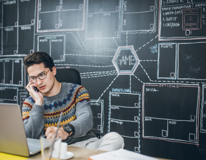 Man-working-in-office-with-charts-in-the-background