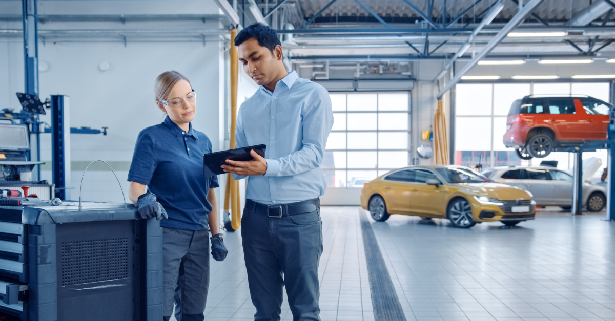 Woman and man looking at data at an tablet in automotive shop