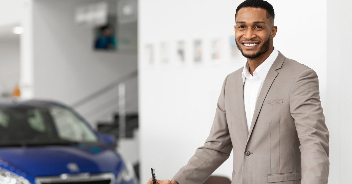 Car Sales Manager Standing In Luxury Dealership Office