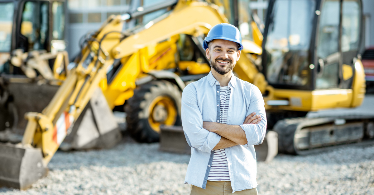 Caucasian man with digital tablet in hand looking at new yellow combine harvester at agricultural equipment dealership