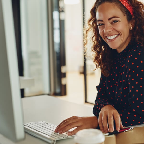 woman at desktop smiling