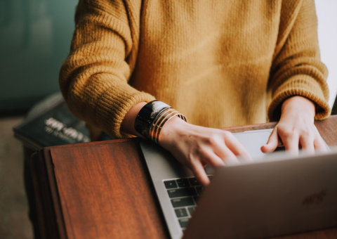 person-in-yellow-sweater-typing-on-laptop