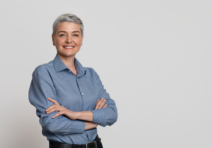 Portrait Of Mature Businesswoman Posing With Folded Arms Over Light Background