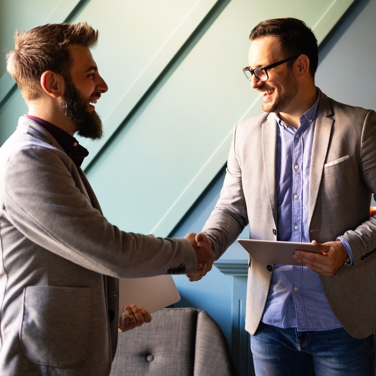 Two-men-shaking-hands-at-work-smiling-TARGIT