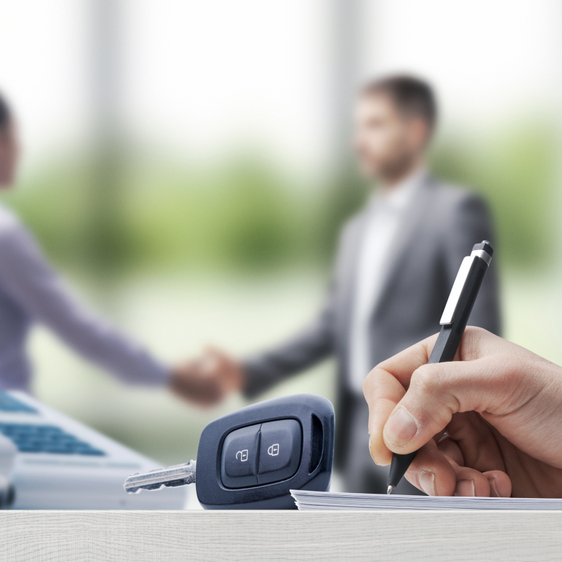 Men shaking hands in front of a car key