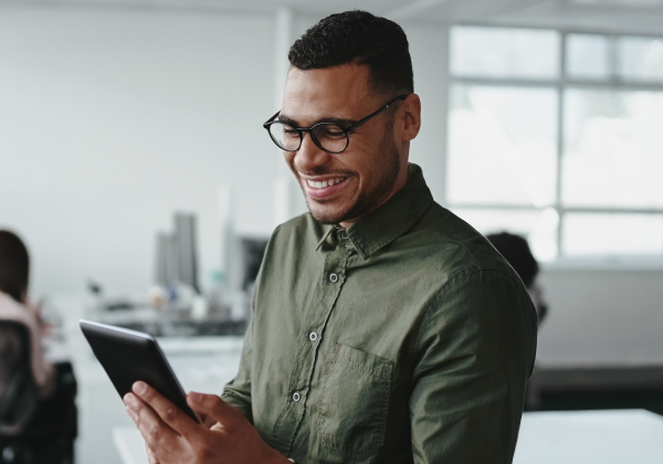 man-smiling-down-looking-at-his-tablet-happy